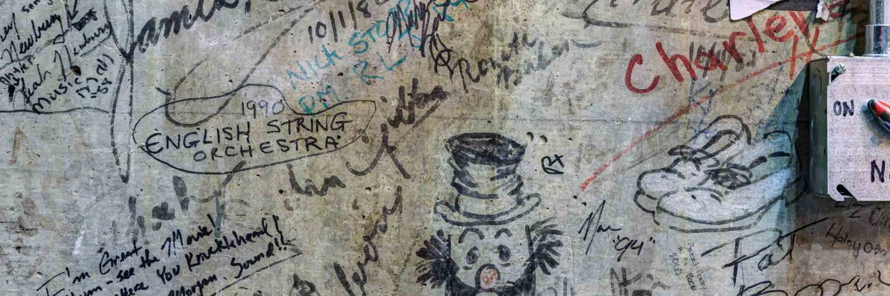 Backstage wall signed by past performers and companies